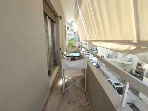 Apartment 110 sqm free parking في باترا: شرفة مع طاولة وكراسي في مبنى