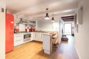 a kitchen with white cabinets and a red refrigerator at Precioso Apartamento en Mercat Sant Antoni in Barcelona