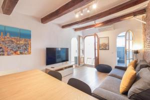 a living room with a couch and a tv at Precioso Apartamento en Mercat Sant Antoni in Barcelona