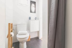 a white bathroom with a toilet and a shower at Precioso Apartamento en Mercat Sant Antoni in Barcelona