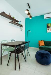 a dining room with a table and chairs and a couch at הרצל בוטיק מבית דומוס - Herzl Boutique Apartments by Domus in Beer Sheva
