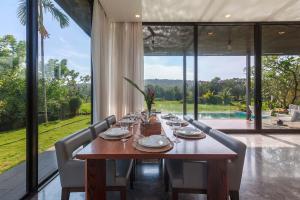 a dining room with a wooden table and chairs at StayVista at Bella Aries in Calangute