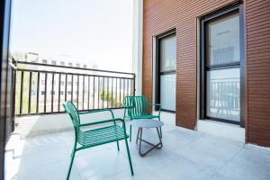 2 sillas y una mesa en el balcón en הרצל בוטיק מבית דומוס - Herzl Boutique Apartments by Domus, en Beer Sheva