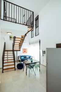 a living room with a staircase and a table at הרצל בוטיק מבית דומוס - Herzl Boutique Apartments by Domus in Beer Sheva