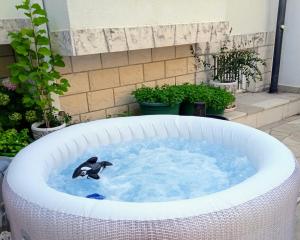 un pingüino en una bañera de hidromasaje en un jardín en VILLA ANA ZIVOGOSCE-Apartment4, en Živogošće