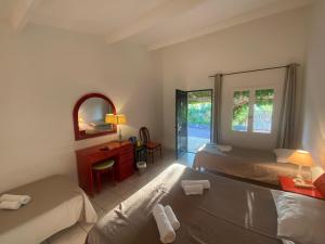 a hotel room with two beds and a mirror at Les Lodges de la Plage U Dragulinu in Sari Solenzara