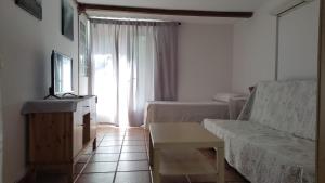 a living room with a couch and a window at Hostal Castilla in Aranjuez