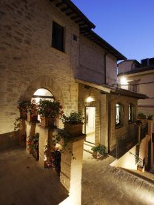 un edificio con macetas al costado. en Hotel Sorella Luna en Assisi