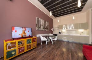 a living room with a tv and a table and a kitchen at Alex Apartments on Lva Tolstogo in Kyiv