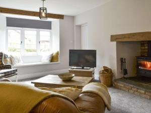 a living room with a couch and a fireplace at Grace Cottage in Umberleigh Bridge