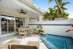 a patio with a table and chairs and a swimming pool at Key Lime Villa in Duck Key