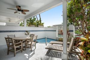 a patio with a table and chairs and a ceiling fan at Key Lime Villa in Duck Key