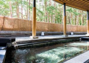 a pool of water in a building with a fountain at Yatsugatake Hotel Fuuka in Hokuto