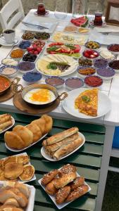 a table filled with plates of food and pastries at Grand Alaçatı Butik Hotel in Alaçatı