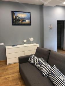 uma sala de estar com um sofá e uma pintura na parede em Apartment Windau em Ventspils