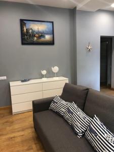a living room with a couch and a painting on the wall at Apartment Windau in Ventspils