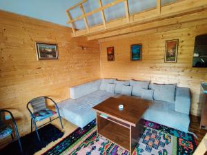 um quarto com um sofá, uma mesa e uma cadeira em Prokosko Resort em Fojnica