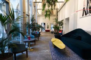 un couloir avec des plantes et des canapés dans un bâtiment dans l'établissement Hotel Indigo Milan - Corso Monforte, an IHG Hotel, à Milan