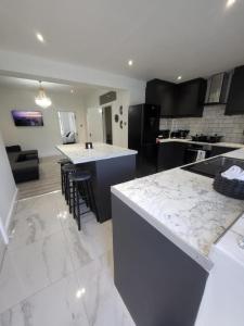 a kitchen with white marble counter tops and a kitchen island at Eastend Apartments in London
