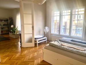 ブダペストにあるRadnoti design Studioのベッド1台、窓、ドアが備わる客室です。