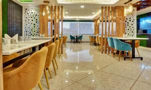 a restaurant with chairs and tables in a room at Hotel Prem Residency in Patna