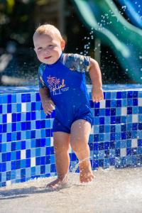 um menino parado na água em uma piscina em San Lameer Villa 3108 - 4 Bedroom Classic - 8 pax - San Lameer Rental Agency em Southbroom