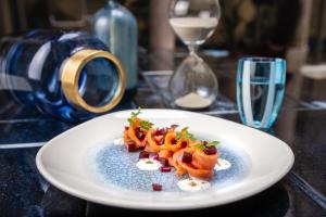 a white plate with food on a table at Hotel Indigo Milan - Corso Monforte, an IHG Hotel in Milan