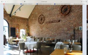 a restaurant with tables and chairs and a brick wall at OASE im grünen Hinterhof, EG, Ruhe, Terrasse, Carport, free PayTV, Kaffee&Tee, Fahrräder in Duisburg