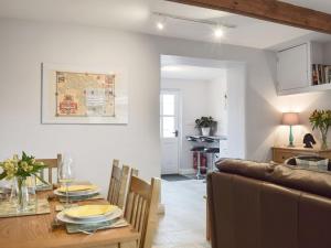 a dining room and kitchen with a table and a couch at Weavers Cottage in Bingley