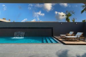 una piscina con 2 sillas y una fuente en Q Hotel Resorts -Riyadh, en Riad