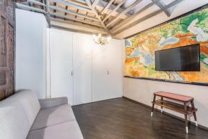 a living room with a couch and a tv on a wall at Firenze Rentals Accademia in Florence