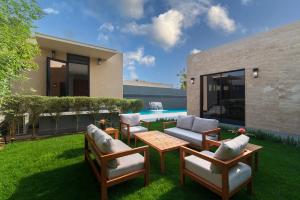 a patio with chairs and a table and a pool at Q Hotel Resorts -Riyadh in Riyadh