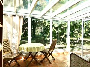 a screened in porch with a table and chairs at Villa Melodie St Remy 6HA Piscine in Saint-Rémy-de-Provence