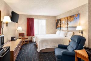 a hotel room with a bed and a television at Days Inn by Wyndham Hurley in Hurley