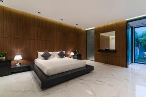 a bedroom with a white bed and a wooden wall at Q Hotel Resorts -Riyadh in Riyadh