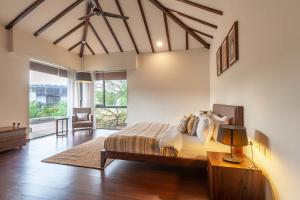 um quarto com uma cama e uma mesa com um candeeiro em Bella Norma with Pool - North Goa at StayVista em Calangute