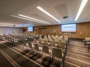 a conference room with chairs and a projection screen at Pullman Brussels Centre Midi in Brussels