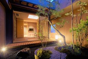 a house with a japanese garden at night at Gozan Hotel & Serviced Apartment Higashiyama Sanjo in Kyoto
