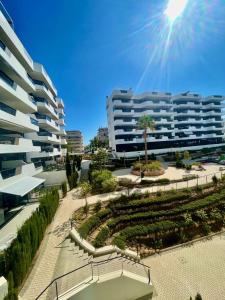 um grande edifício de apartamentos com um jardim em frente em BArenales Sun Apart em Arenales del Sol