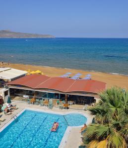 Nektar Beach Hotel في ستالوس: منتجع فيه مسبح بجانب شاطئ