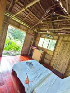een kamer met een groot bed in een hut bij Canjahawon Nipa Hut Homestay in Siquijor