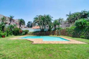a swimming pool in the yard of a house at 9 Skiathos - Beach front apartment - Salt Rock in Ballito