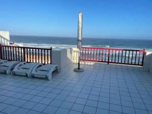 a balcony with chairs and the ocean in the background at 9 Skiathos - Beach front apartment - Salt Rock in Ballito