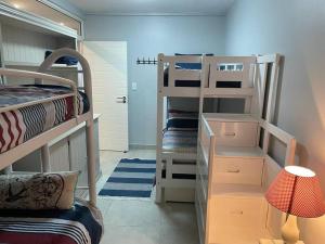 a room with two bunk beds and a lamp at 9 Skiathos - Beach front apartment - Salt Rock in Ballito