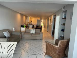 a living room with two couches and a kitchen at 9 Skiathos - Beach front apartment - Salt Rock in Ballito