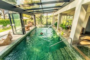 a pool in a house with a person swimming in it at Hotel****Spa & Restaurant Cantemerle in Vence