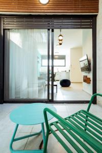 una camera con panchina verde e tavolo di הרצל בוטיק מבית דומוס - Herzl Boutique Apartments by Domus a Beer Sheva