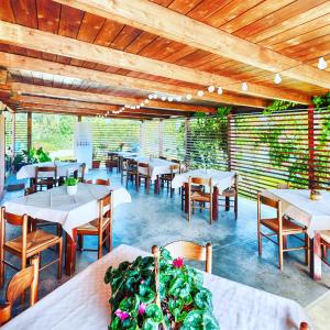 comedor con mesas y sillas y techos de madera en Agriturismo Il Paradiso en Iglesias