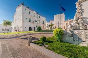 a large white building with a flag on it at Suite Fronte Valle in Cisternino