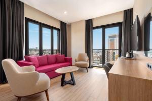 a living room with a pink couch and windows at Tryp by Wyndham Istanbul Atasehir in Istanbul